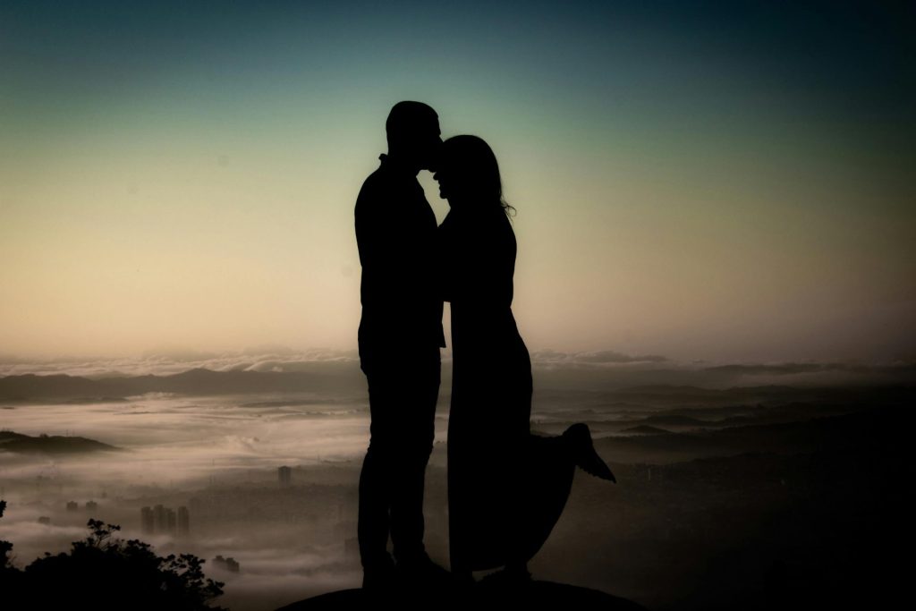 Silhouette eines Paares, das einen zärtlichen Moment im Sonnenuntergang in Mogi das Cruzes, Brasilien, teilt.
